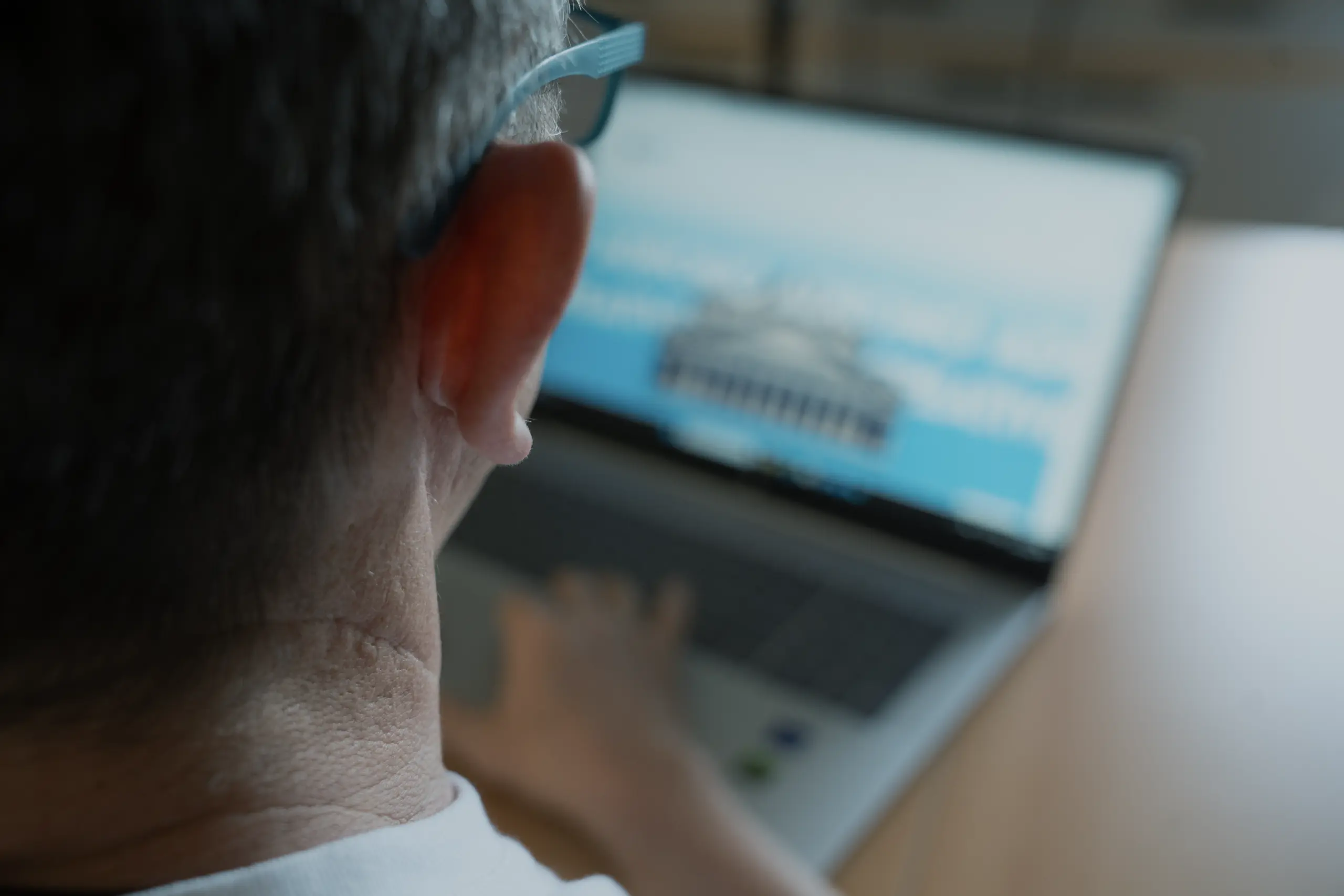 Person arbeitet am Laptop von hinten gesehen